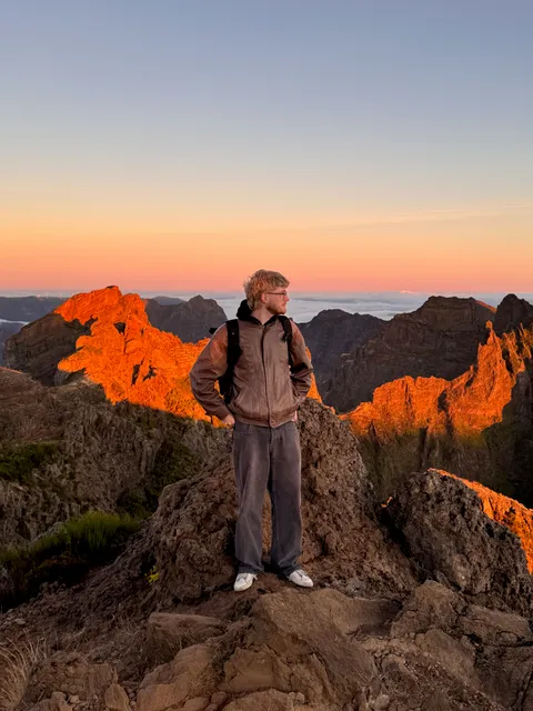 Leonard Zimdars standing on a ridge in the mountains at sunrise